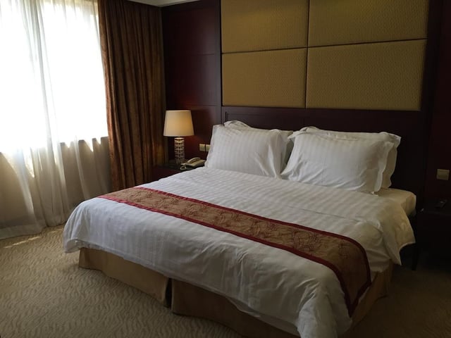 a bed in a hotel room with a large window