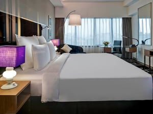 bilik hotel dengan katil besar dan televisyen