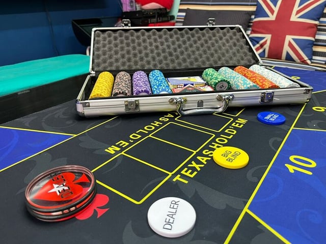 a blackjack roing table with a case of chips and a ball