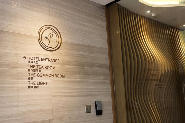 the entrance to the hotel with a wooden wall