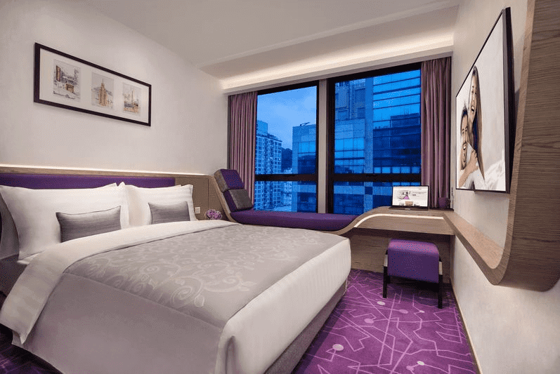 有一張床和紫色地毯的飯店房間