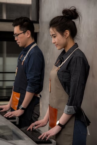 a man and a woman are working on a computer
