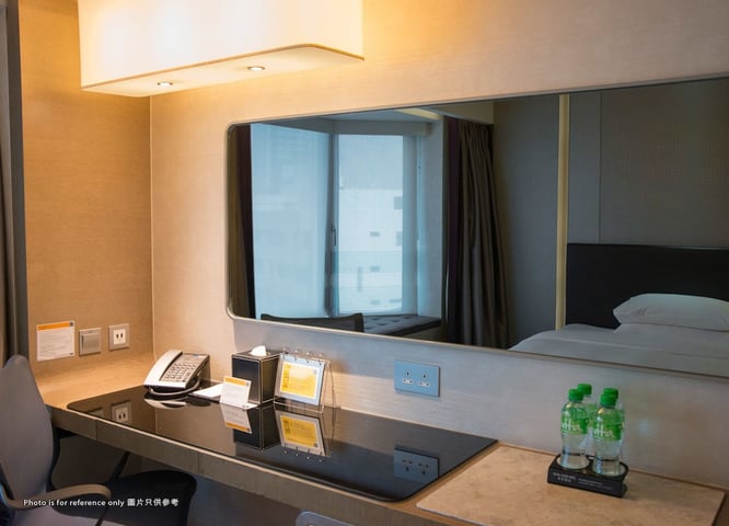a hotel room with a desk and mirror